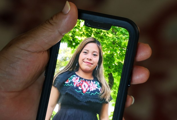 A photo of Marina Lopez Perez from last year is held by her husband on Aug. 1, 2025. (Stacey Wescott/Chicago Tribune)