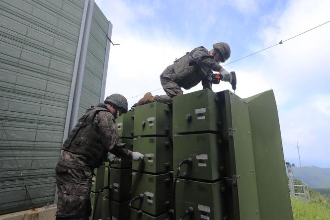 This handout photo taken on August 4, 2025, and provided by the South Korean Defense Ministry shows South Korean soldiers removing loudspeakers that were set up for propaganda broadcasts near the demilitarized zone separating the two Koreas in an undisclosed location in South Korea.