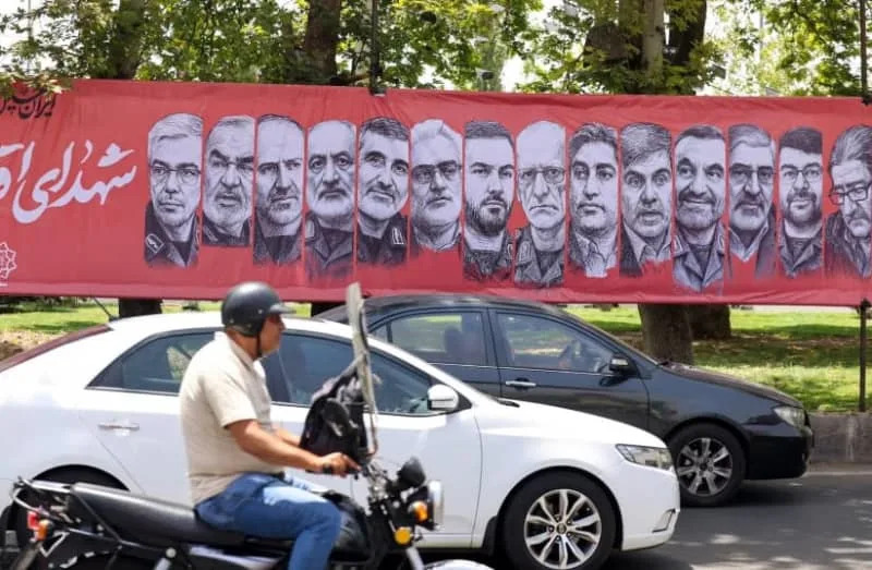 Traffic moves past a large banner depicting Iranian commanders and scientists killed in Israeli strikes during the 12-day war between Iran and Israel, at Tajrish Square in the capital Tehran, June 30, 2025. (credit: Atta Kenner /AFP via Getty Images)