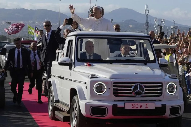 Pope Leo greets the crowd from the Popemobile