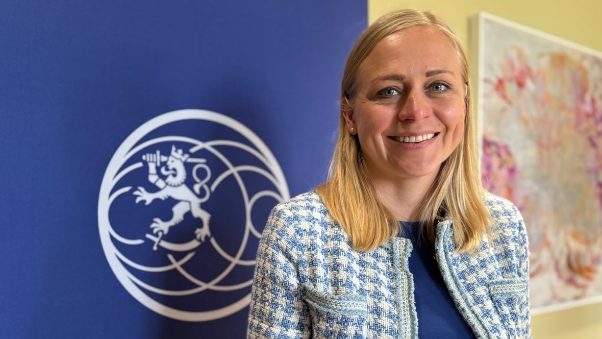 A woman with blonde hair smiles for a photo