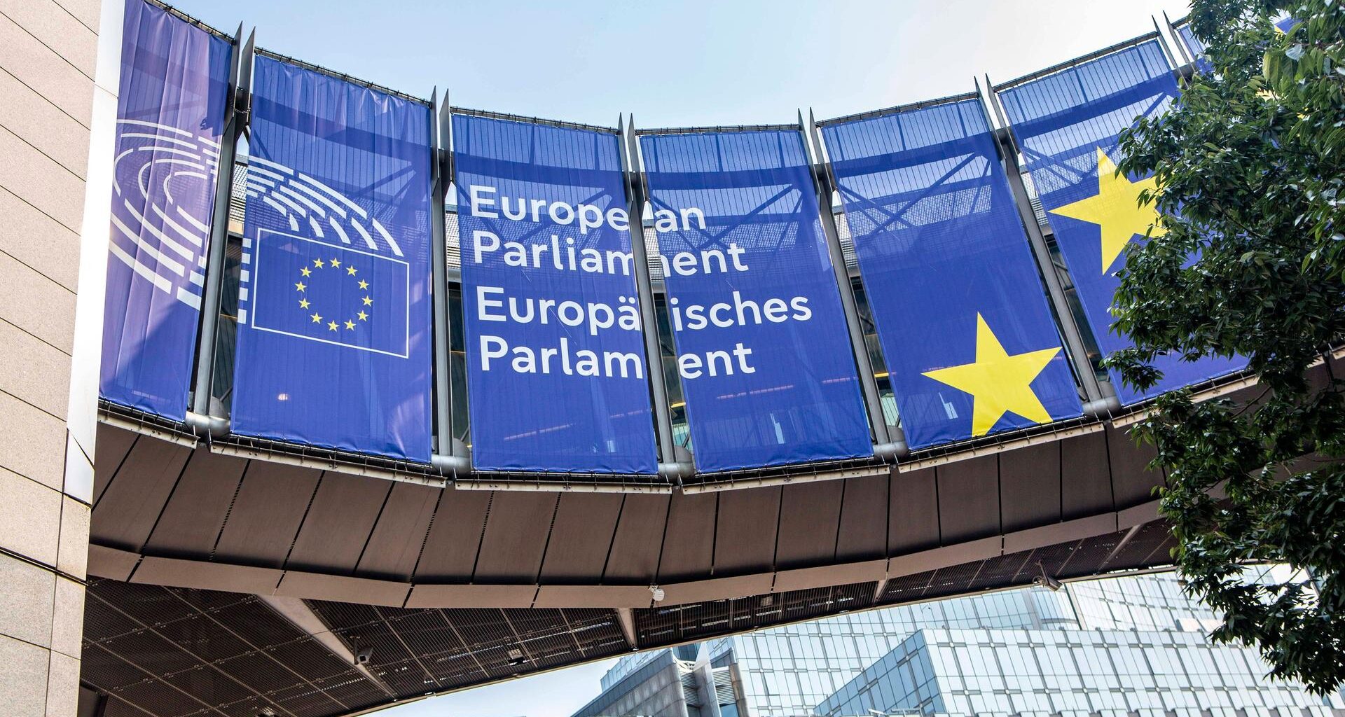 Vor dem Europäischen Parlament hängen blaue Transparente mit dem Namen und Logo des Parlaments.
