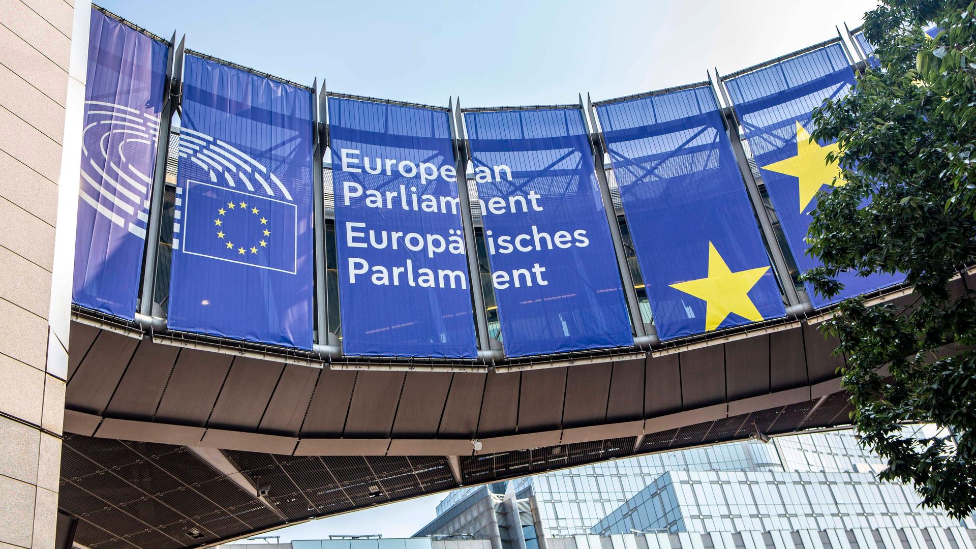Vor dem Europäischen Parlament hängen blaue Transparente mit dem Namen und Logo des Parlaments. Vor dem Europäischen Parlament hängen blaue Transparente mit dem Namen und Logo des Parlaments.