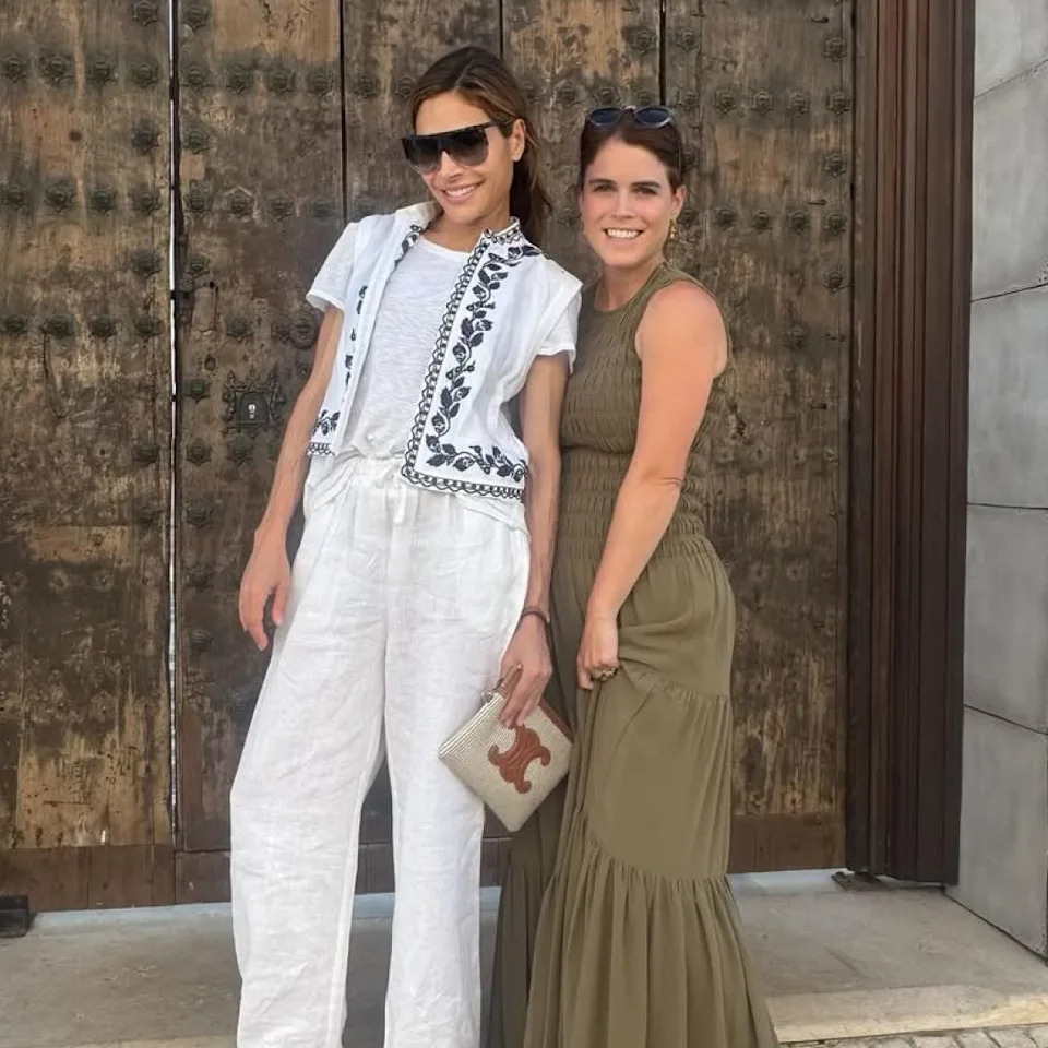  Princess eugenie wearing a green maxi dress standing with Ayda Field Williams in front of a door . 