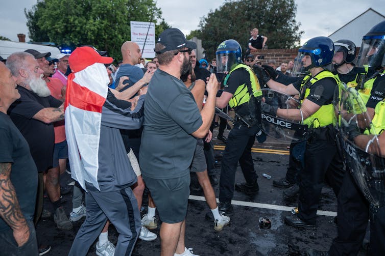 protesters clash with police holding riot shields
