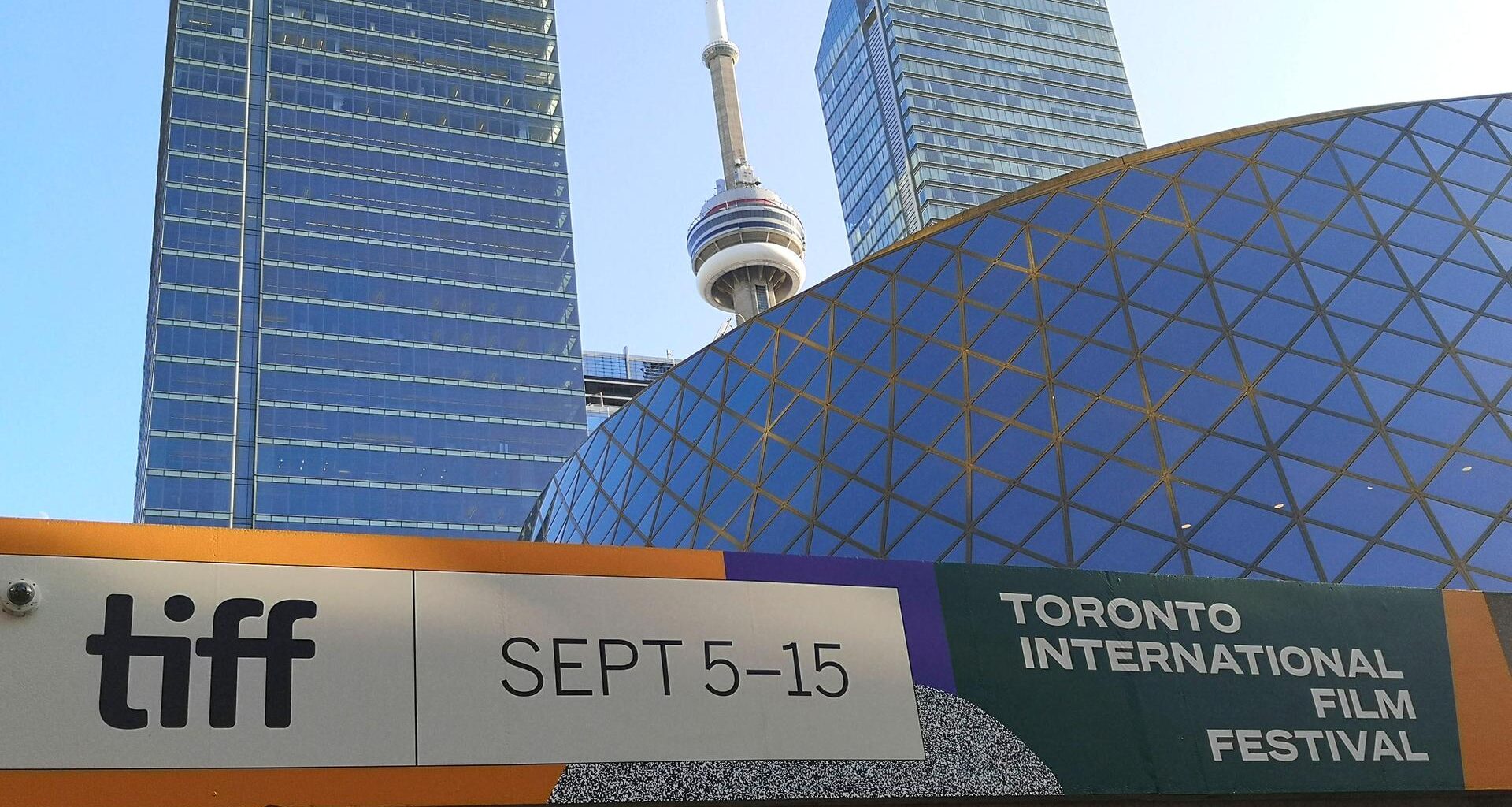 Ein Plakat an einer Wand vor einem modernen Gebäude weist auf das Filmfestival in Toronto hin.