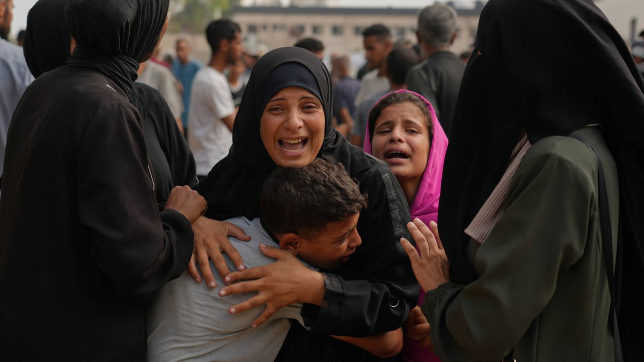 A woman whose son was killed while trying to reach aid trucks is comforted by relatives outside Shifa Hospital before her son's funeral in Gaza City, Thursday, Aug. 21, 2025. (AP Photo/Jehad Alshrafi)