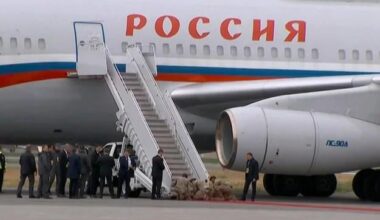 This is how you greet a war criminal: Your soldiers kneeling and placing a red carpet in front of his plane!