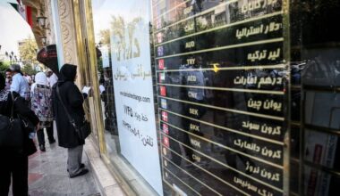 People gather outside a foreign exchange office in Tehran