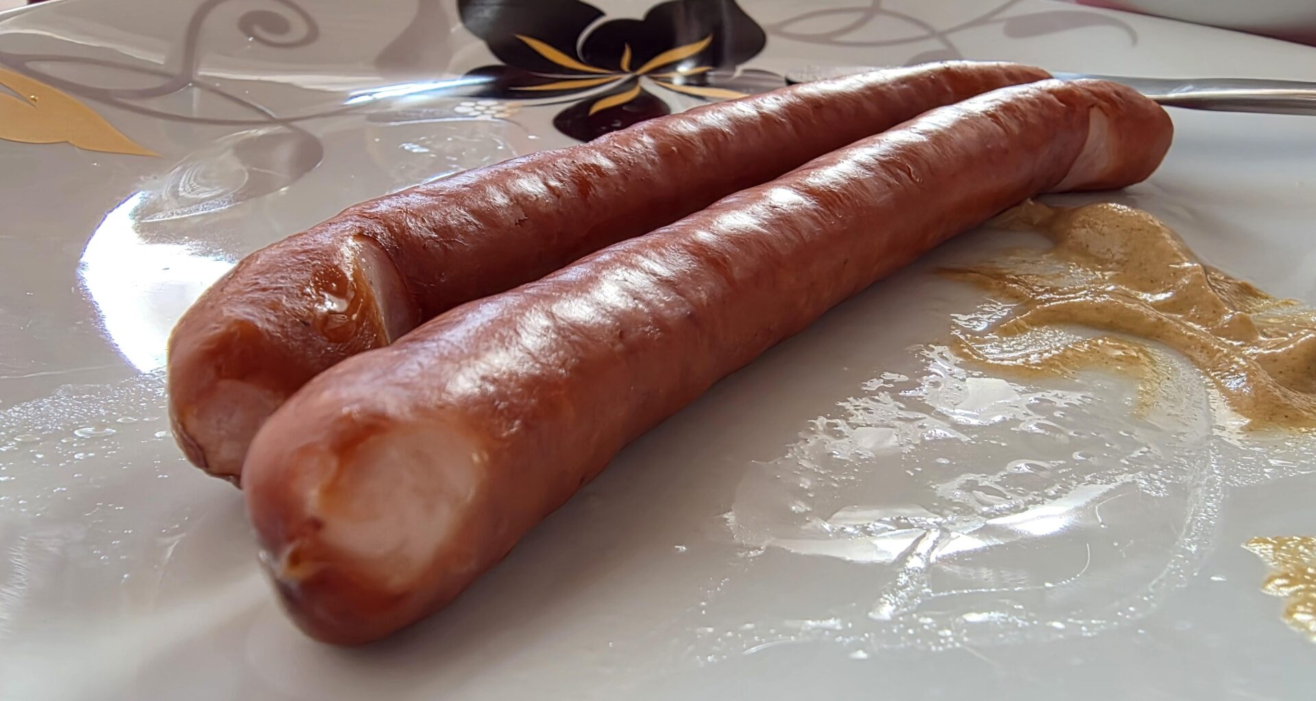How do I avoid 3rd degree burns from the geyser after cutting into the kiełbasa?
