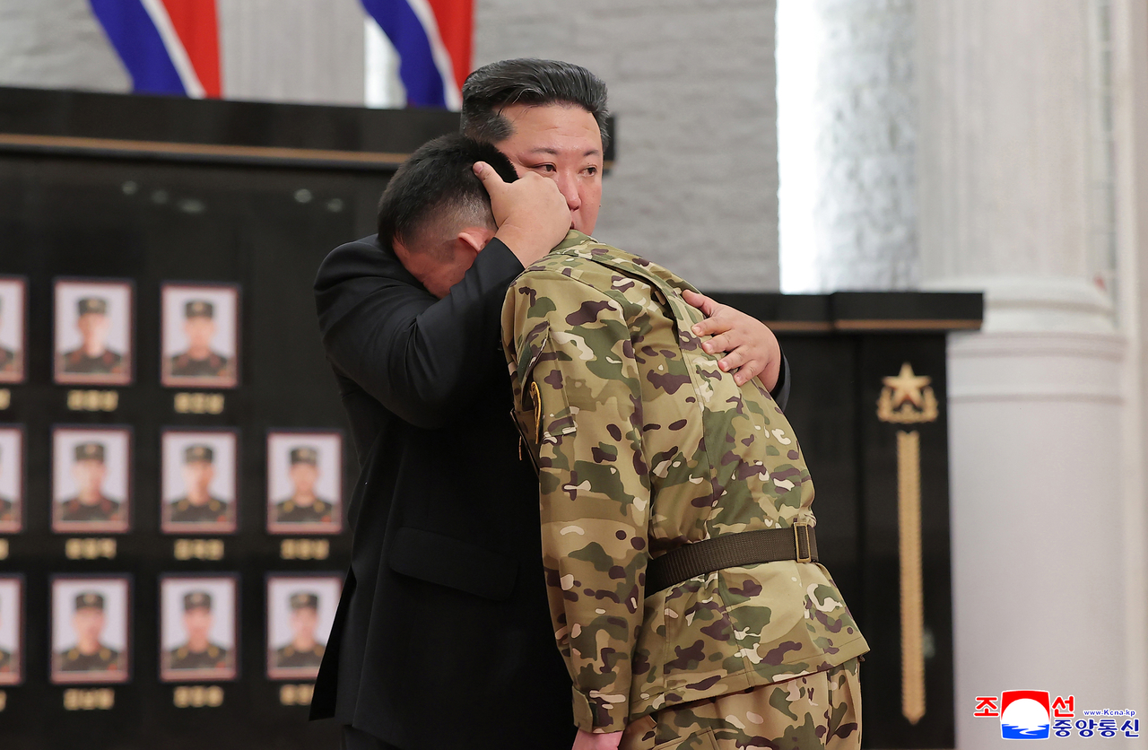 North Korean leader Kim Jong-un (left) appears overcome with emotion as he embraces a soldier during a ceremony in Pyongyang to award state commendations to commanders and combatants deployed to Russia's war with Ukraine and to comfort the bereaved families of fallen soldiers, in this undated photo released by the North's official Korean Central News Agency on Friday. (Yonhap)