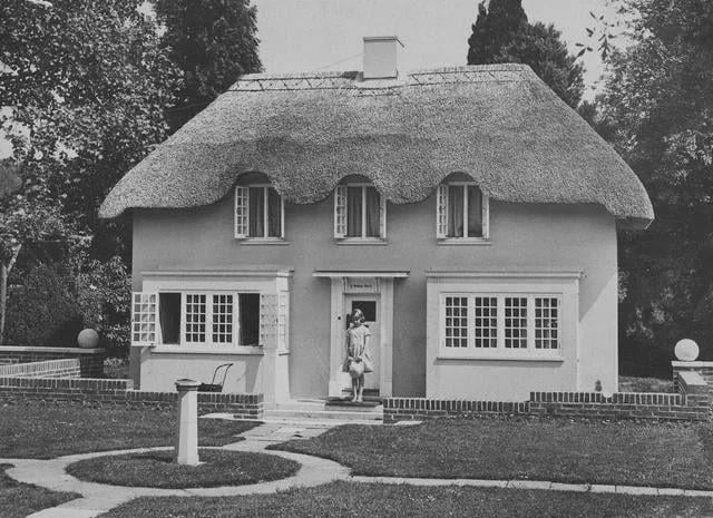The future Queen Elizabeth in front of a playhouse gifted to her and Princess Margaret in 1932 by the people of Wales.