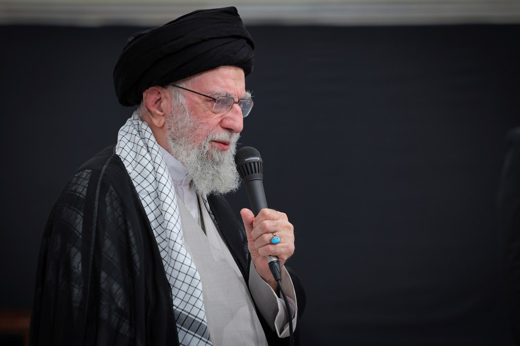 Ayatollah Ali Khamenei speaking at a microphone.