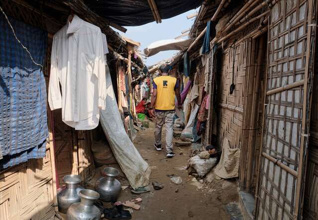An IRC staff member walks through the crowded streets of Cox's Bazar refugee camp.