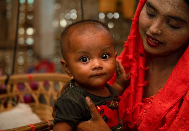 A Rohingya refugee in Cox’s Bazar, Bangladesh, holds her young child in her arms.