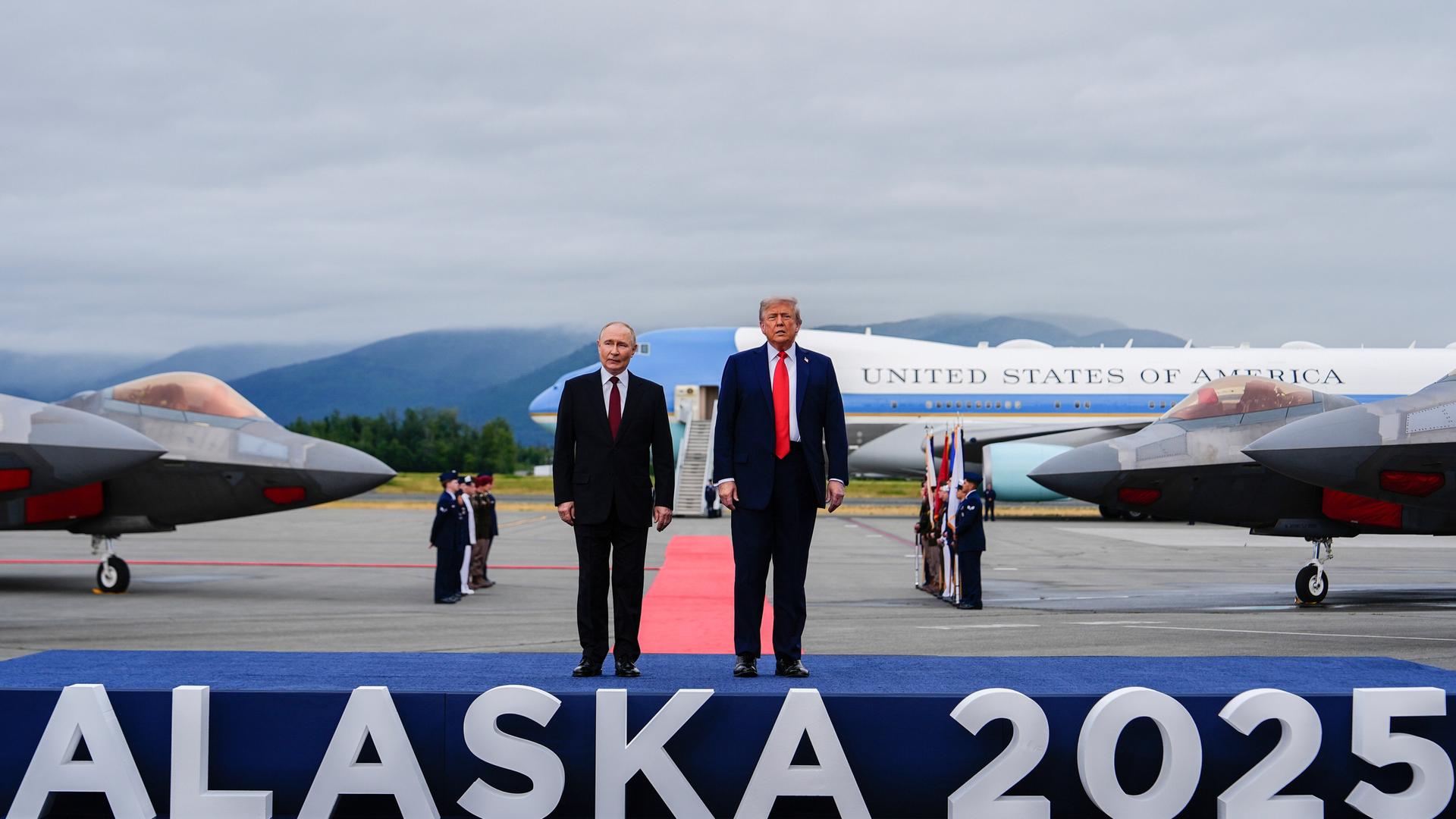 US-Präsident Donald Trump und der russische Präsident Wladimir Putin stehen auf einem Flughafen auf einem Podest, auf dem "Alaska 2025" steht. US-Präsident Donald Trump und der russische Präsident Wladimir Putin stehen auf einem Flughafen auf einem Podest, auf dem "Alaska 2025" steht.