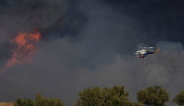 A helicopter flies through smoke in Keratea on the outskirts of Athens. Pic: AP