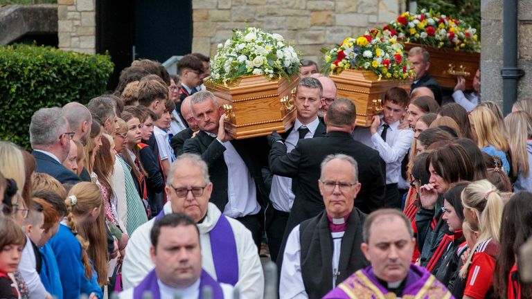 The coffins are carried from St Mary's Church in Maguiresbridge, Co Fermanagh, following a service of removal. Pic: Liam McBurney/PA