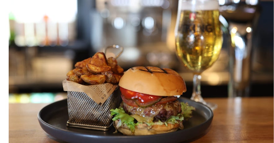 Juicy burger with golden fries and a refreshing glass of beer at Krisp Resturant in Selfoss, Iceland.