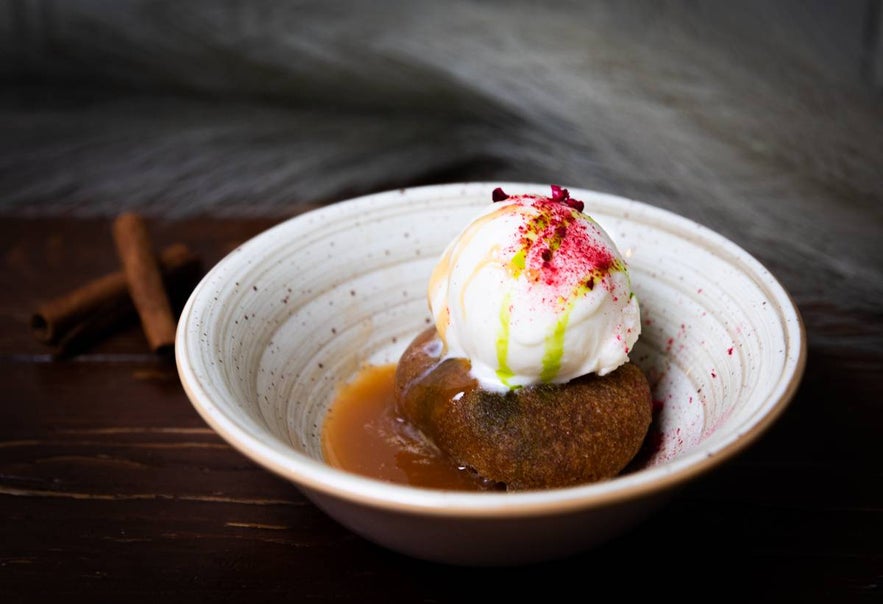 Sticky toffee pudding with vanilla ice cream and berry dust at Tryggvaskali in Selfoss, Iceland.