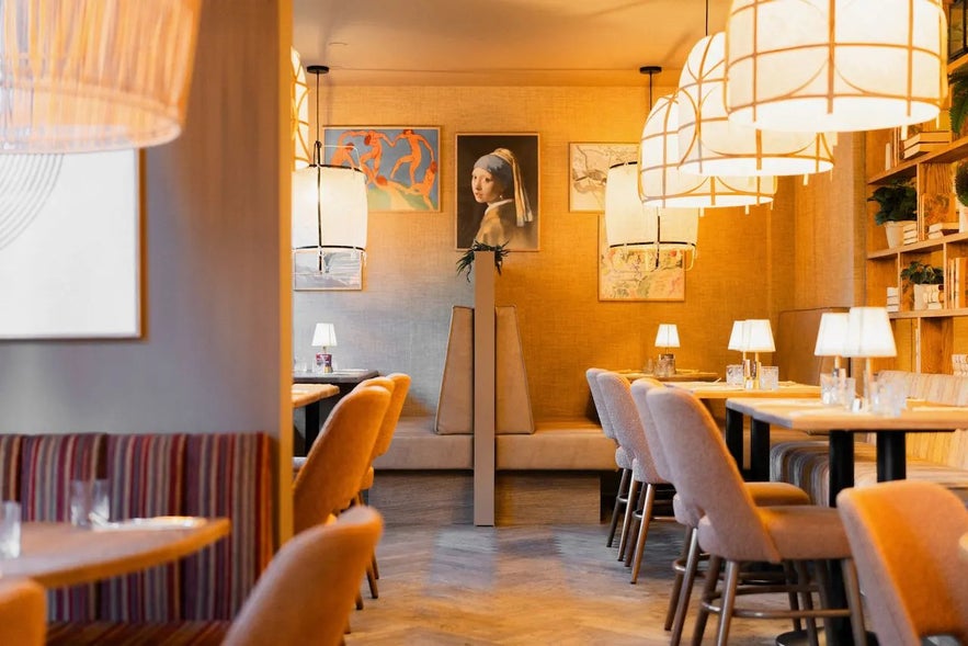 Stylish restaurant interior with warm lighting, modern art, and cozy seating at Froken Selfoss.
