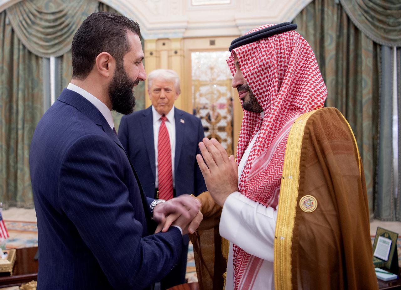 A handout picture provided by the Saudi Royal Palace shows Saudi Crown Prince Mohammed bin Salman (R) greeting Syrias interim president Ahmed al-Sharaa as US President Donald Trump looks on, in Riyadh on May 14, 2025. (Photo by Bandar AL-JALOUD / Saudi Royal Palace / AFP)