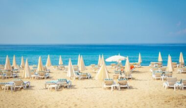 Sun loungers and umbrellas arranged on a sandy beach in Antalya, Türkiye. (Adobe Stock Photo)