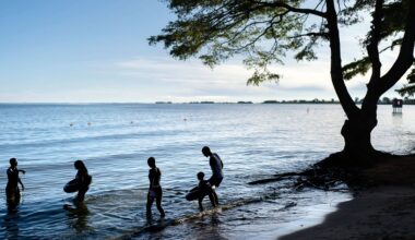 People wade into the waters of Lake Victoria, the world's second-largest freshwater lake, Nov. 25, 2024, in Entebbe, Uganda. (AP Photo/David Goldman, File)