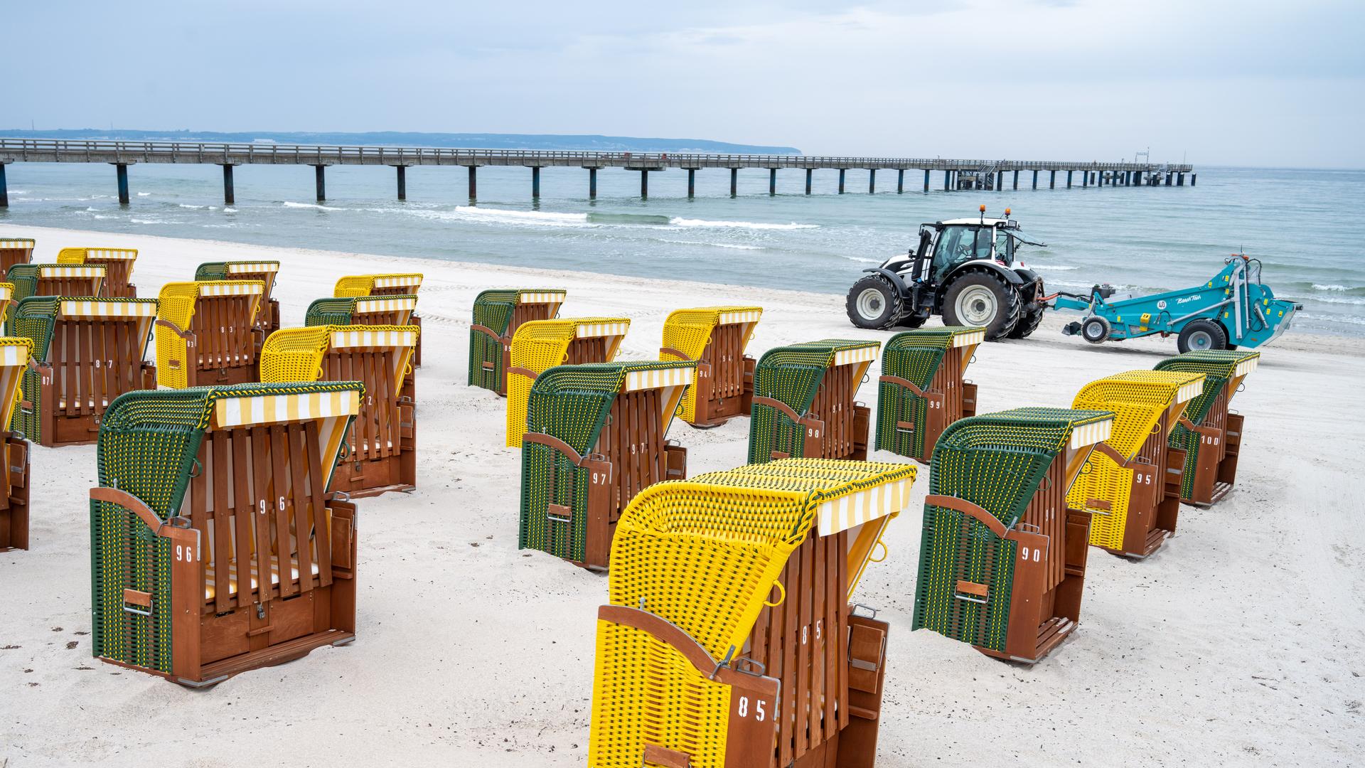 Strandkörbe stehen vor der Seebrücke auf der Insel Rügen am Ostseestand. 