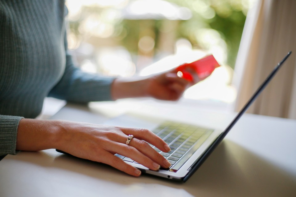 Woman using laptop and credit card for online shopping.