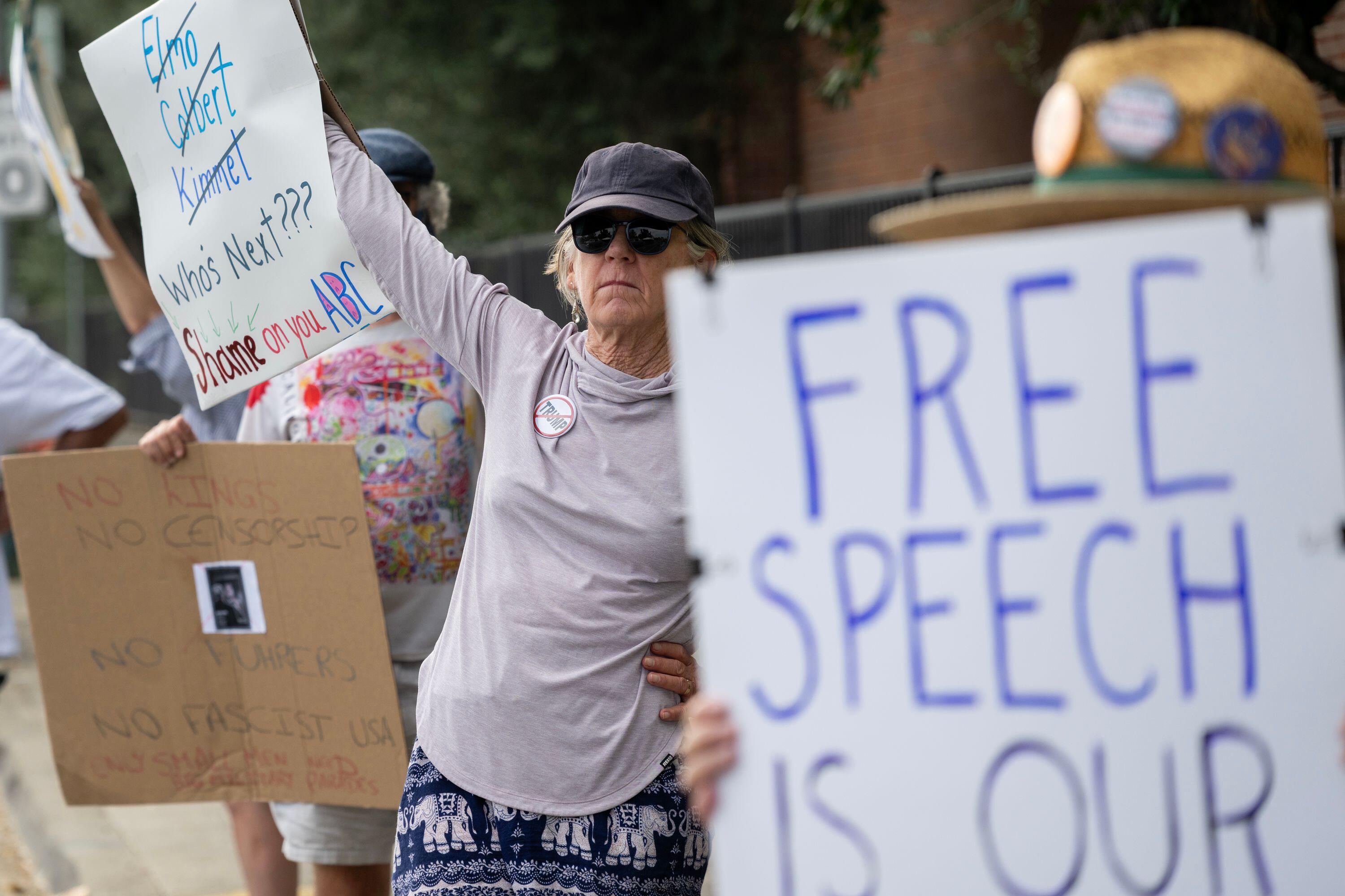 Protestors holding signs advocating for free speech.