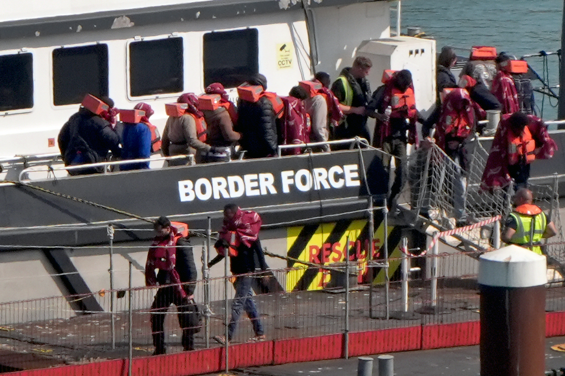 Migrants disembarking a Border Force vessel in Dover.