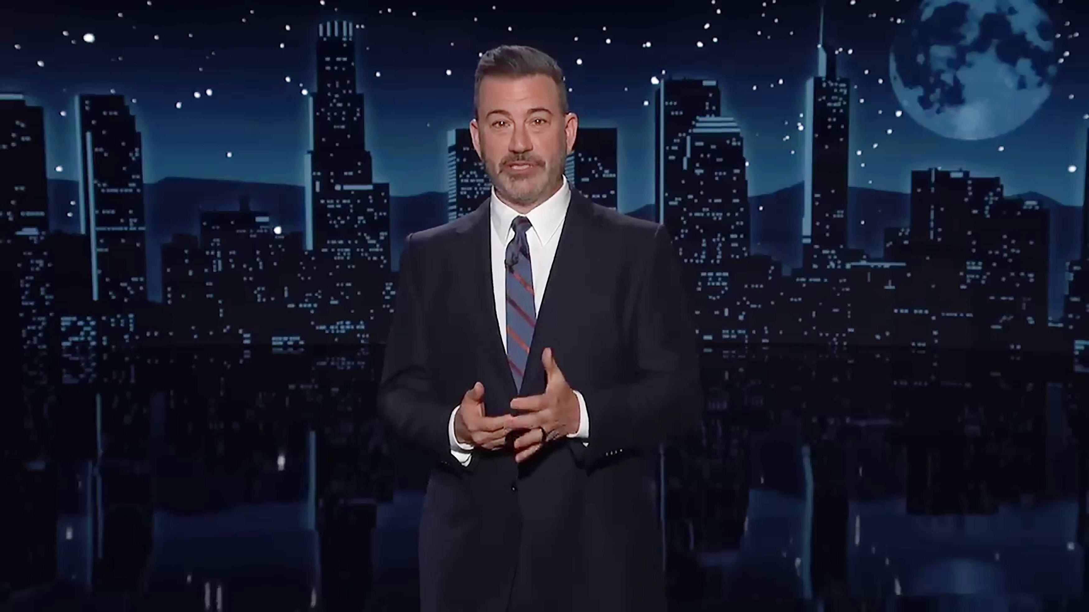 Jimmy Kimmel in front of a nighttime cityscape.