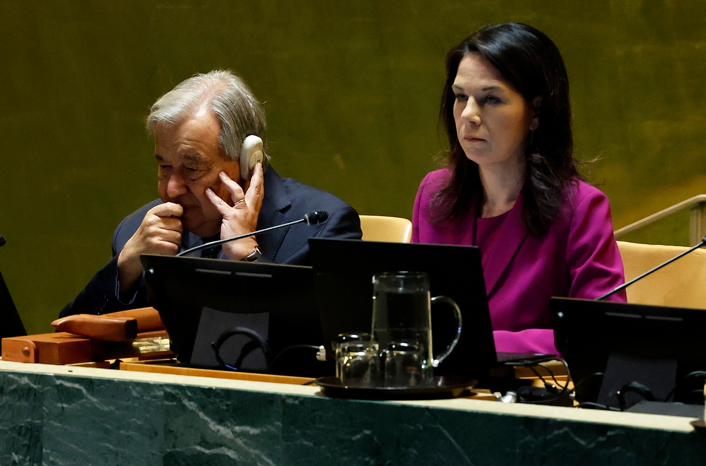 The secretary general António Guterres and president of the general assembly Annalena Baerbock watch on as Trump speaks, with pained expressions