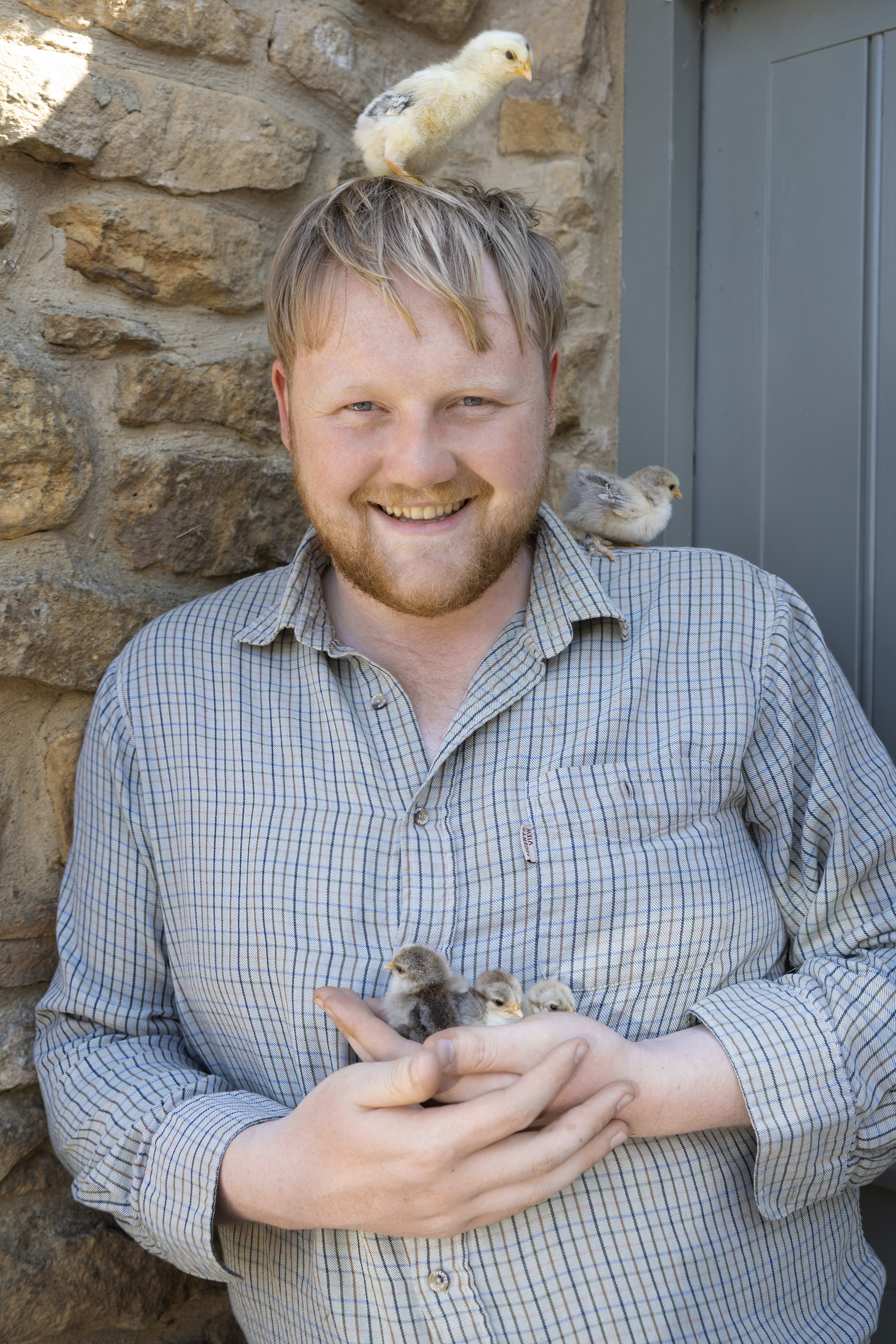 Kaleb Cooper holding baby chicks on Jeremy Clarkson's farm.