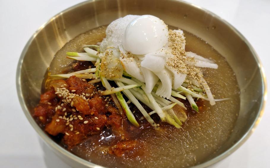 A bowl of noodles and toppings.