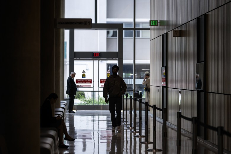 The silhouette of a person as they walk through a hallway during a legislative hearing at a building near the state Capitol.