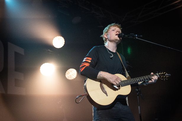 Ed Sheeran performing on stage with a guitar