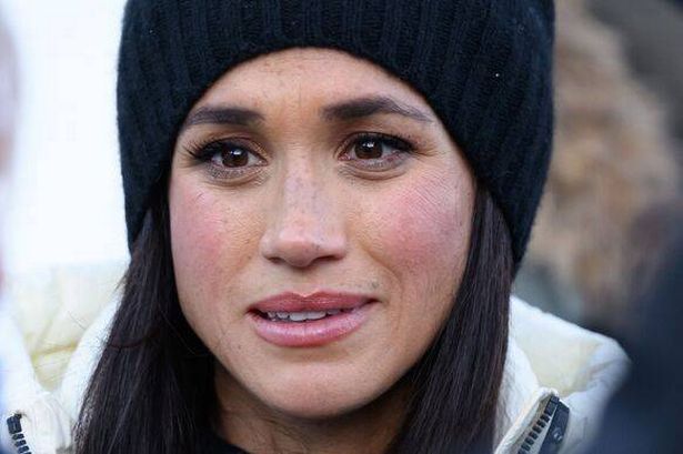 Meghan Markle wearing black beanie hat and white jacket