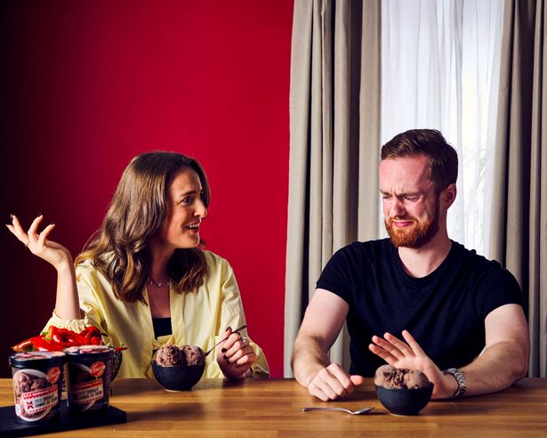 Man and woman in front of a bowl of chocolate ice cream - the man is grimacing and pushing the bowl away