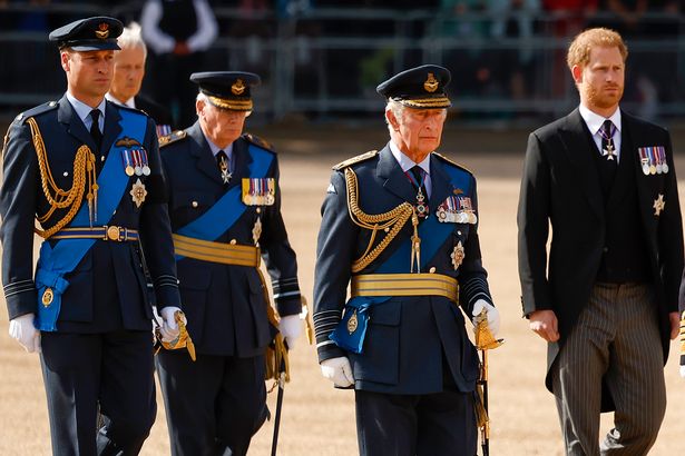 Prince William, Prince of Wales, King Charles III and Prince Harry, Duke of Sussex walk behind the Queen's coffin