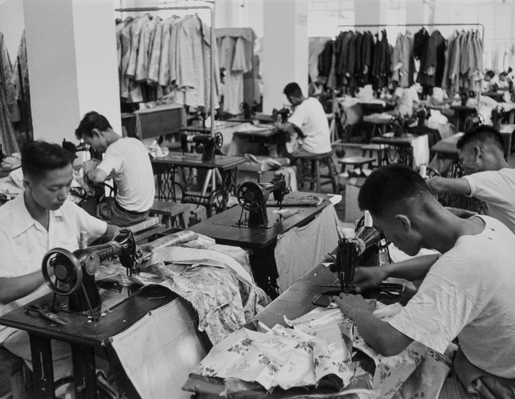Workers using sewing machines to make garments at a clothing factory in Hong Kong, circa 1960. Photo: Getty Images