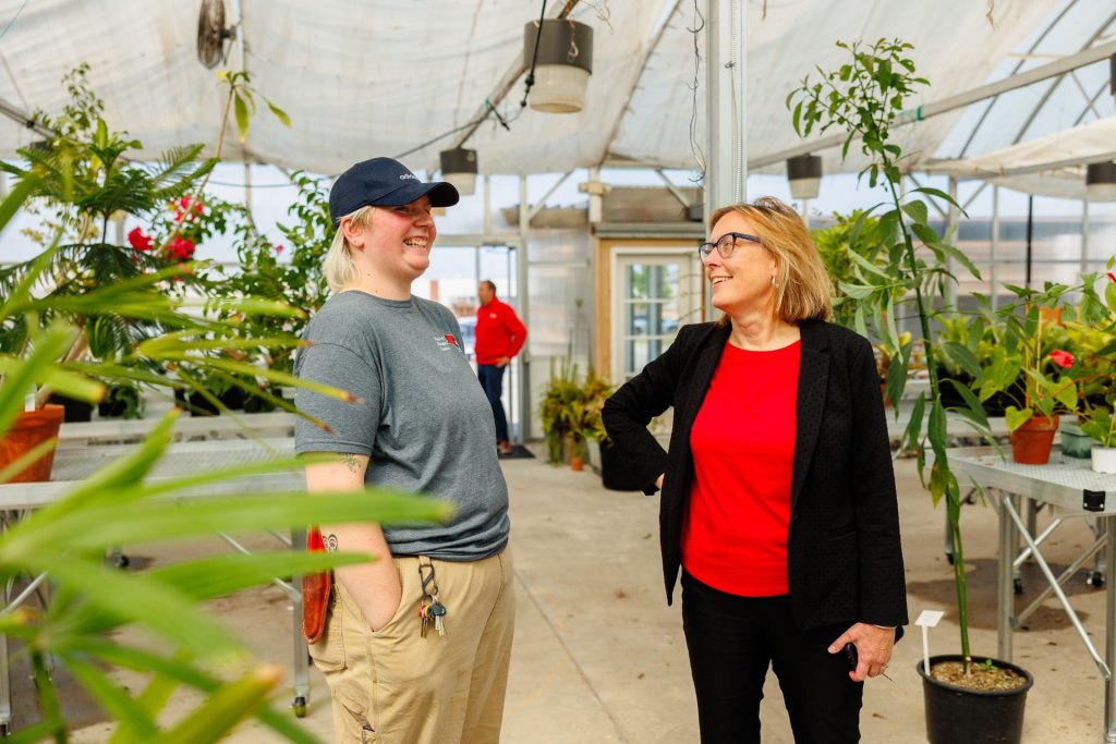 two people talking in a greenhouse