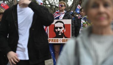 An Adelaide man spotted holding a poster of fugitive Dezi Freeman at a March for Australia rally on Sunday has been charged