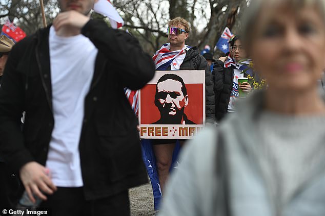 An Adelaide man spotted holding a poster of fugitive Dezi Freeman at a March for Australia rally on Sunday has been charged