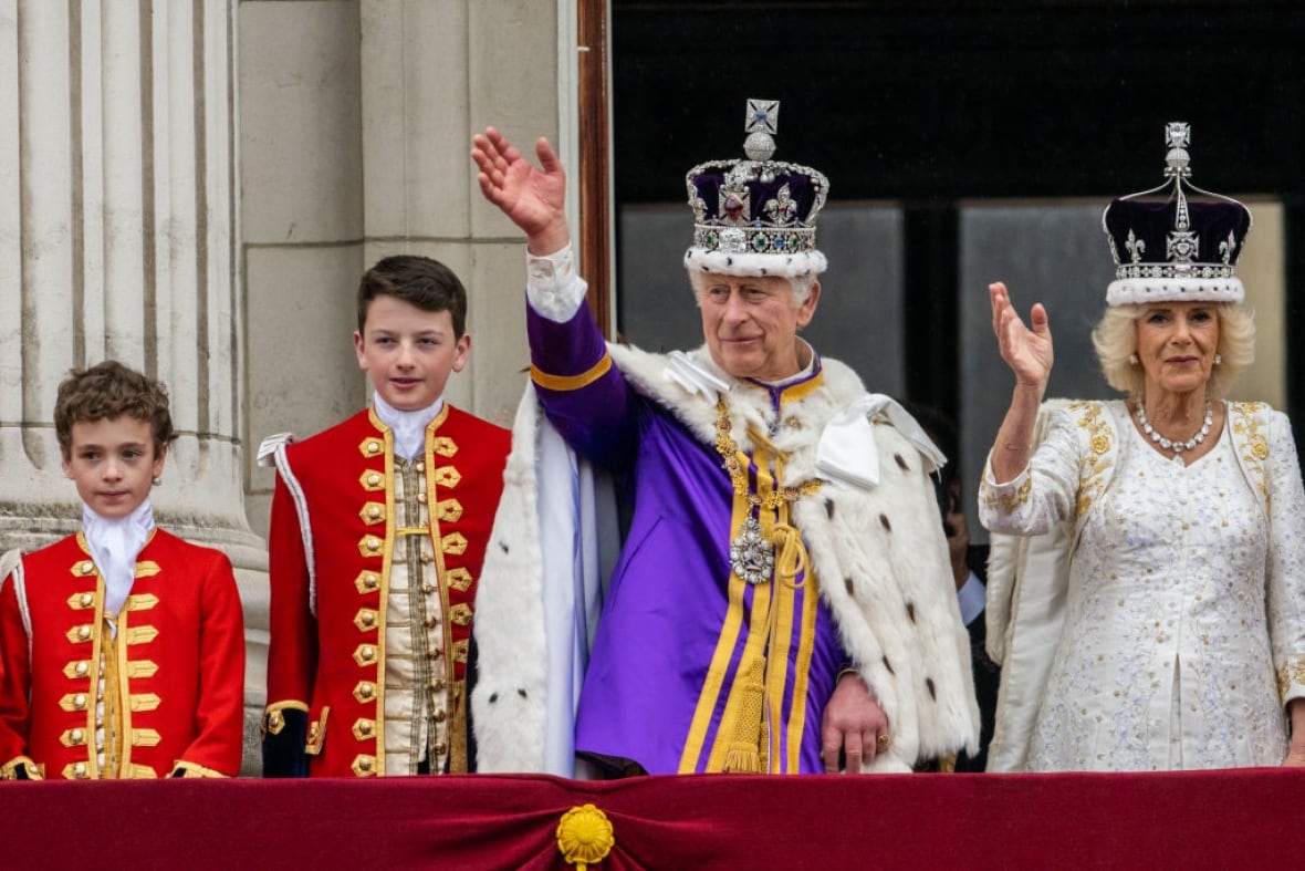 People wave from a balcony.