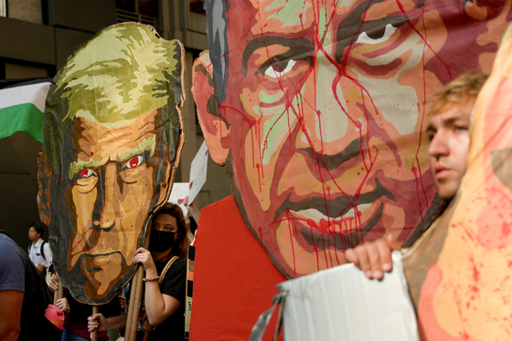 People carry caricature heads of U.S. President Donald Trump, left, and Israeli Prime Minister Benjamin Netanyahu as they march down 54th Street during a pro-Palestinian demonstration, Sept. 26, in New York. [AP/YONHAP]