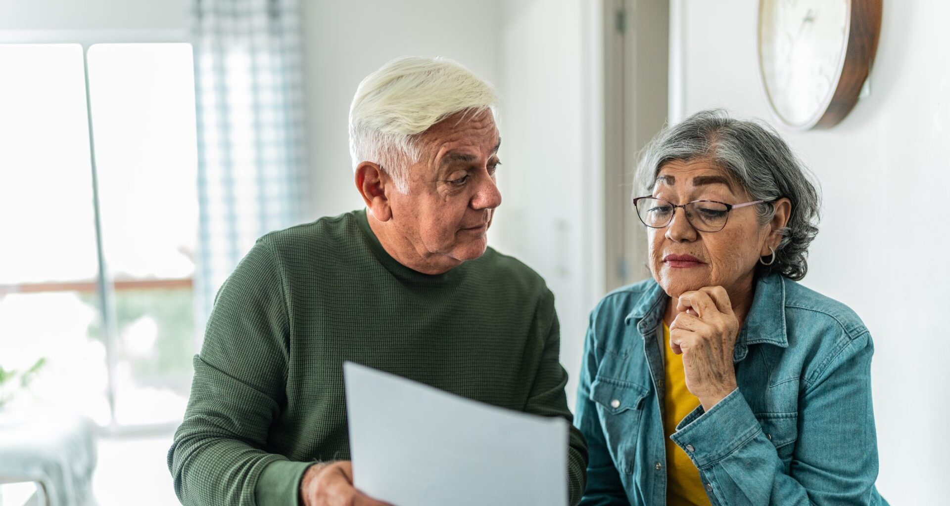 Senior couple using computer and doing home finances at home.