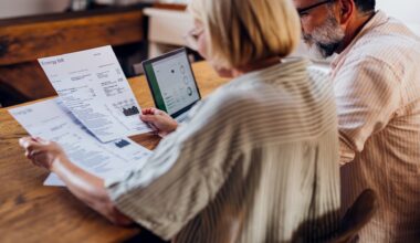 Senior couple carefully reviewing their household energy bill together on a laptop at home.
