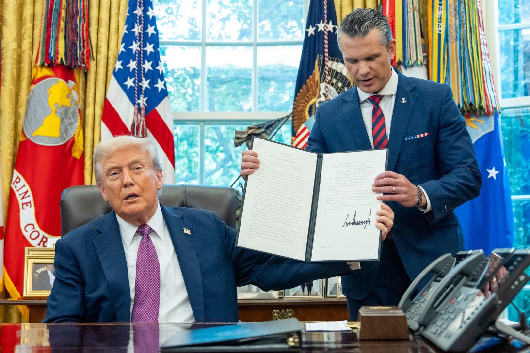 President Donald Trump hands a signed executive order to Defense Secretary Pete Hegseth, in the Oval Office of the White House, on September 5.